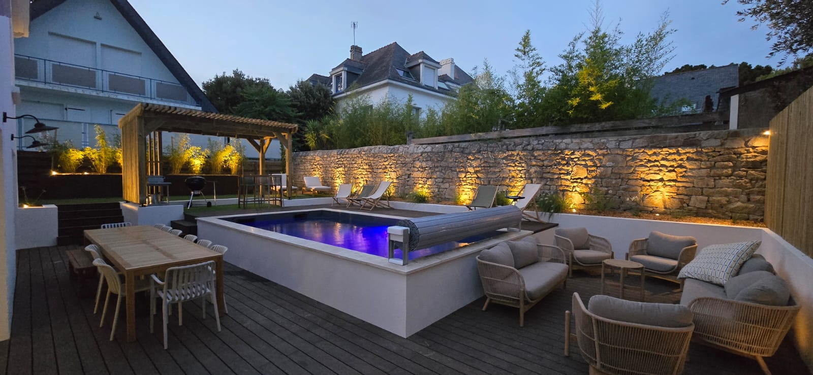 Piscine et terrasse illuminées à la tombée du jour